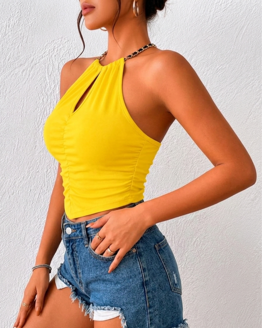 Top jaune doté d'un col halter avec une chaîne métallique
